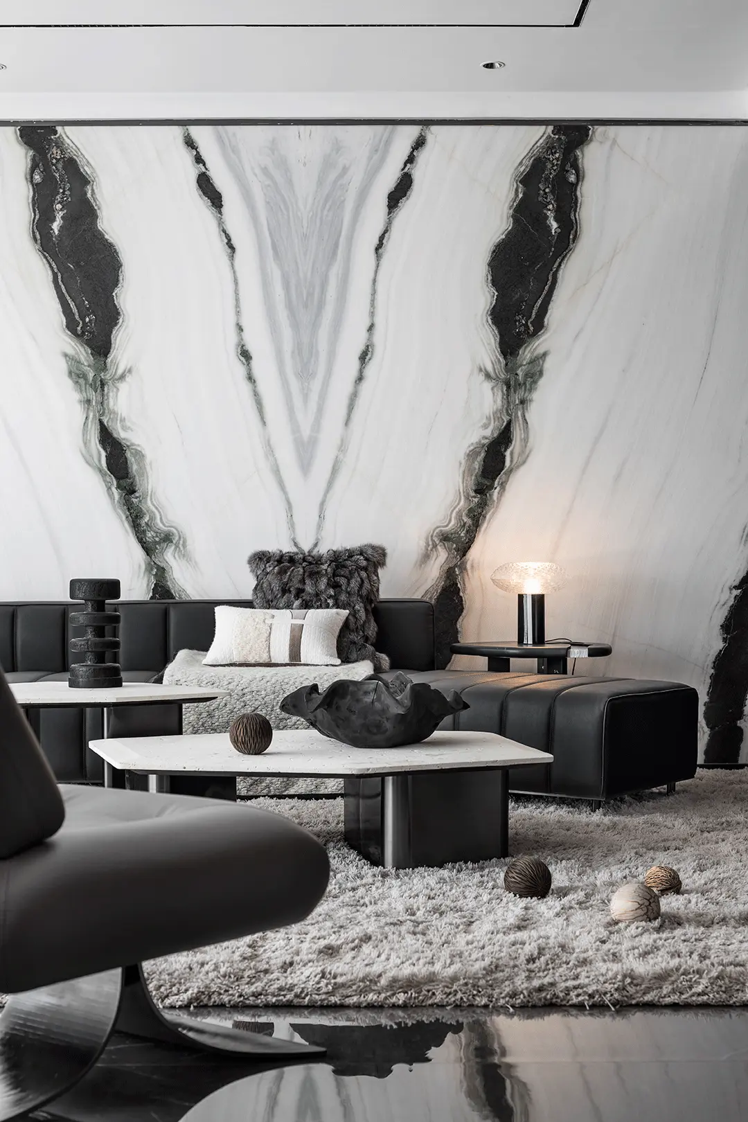 モダンでラグジュアリーなリビングルームにおけるパンダホワイト大理石のブックマッチ機能壁