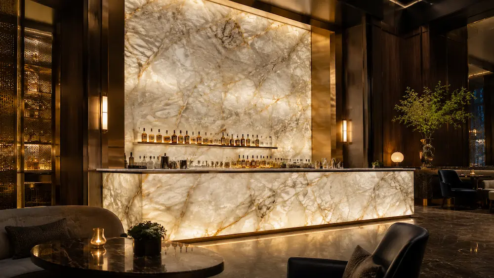 Instalación de pared retroiluminada y mostrador de bar de lujo con cuarcita Cristallo